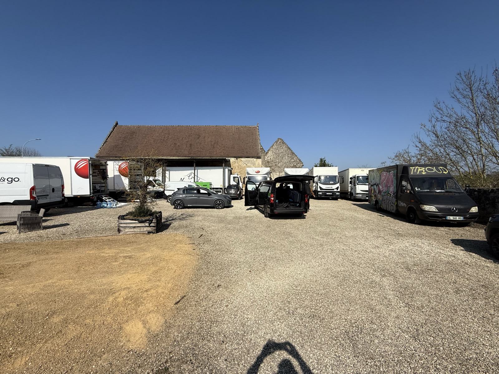 Les camions de production stationnés sur le parking arrière du domaine