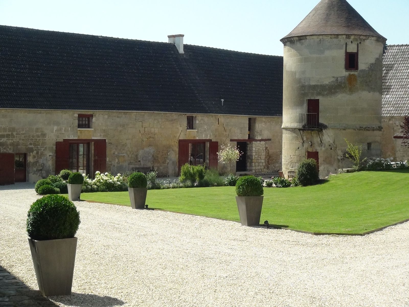 La cour du corps de ferme et son pigeonnier, en plein soleil