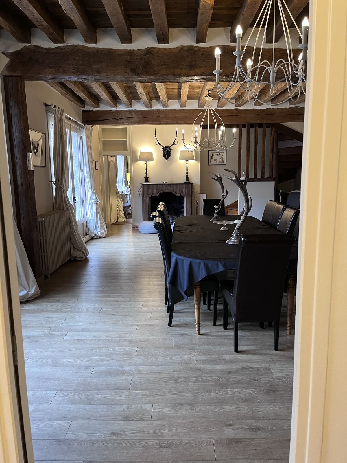 La salle à manger sous les poutres, la cheminée au fond