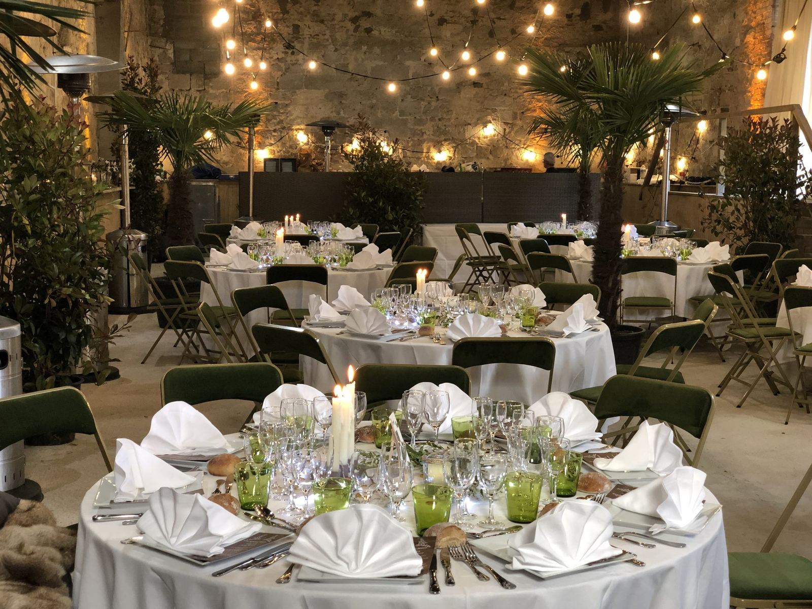 La grange dressée pour un dîner de groupe, guirlandes et tables rondes