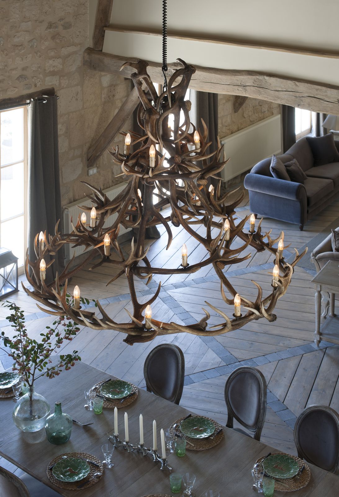 Le lustre en bois de cerf au-dessus de la grande table