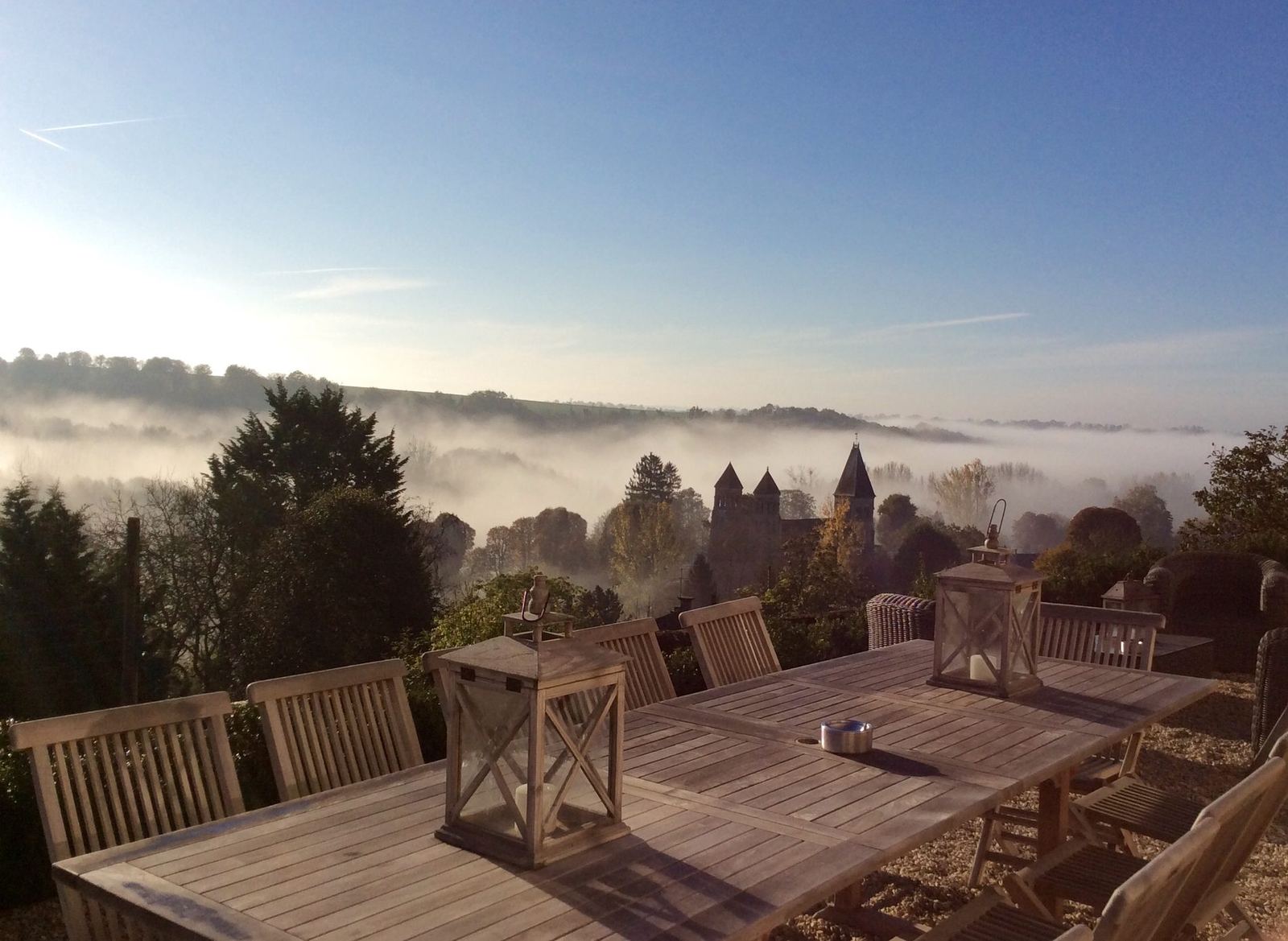La vallée et les tours de l’abbaye romane dans la brume, vues de la terrasse